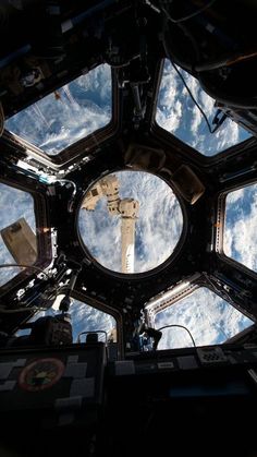 the inside of a space station looking up at the earth's sky and clouds