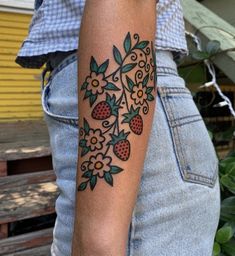 a woman with a tattoo on her arm and some flowers in the middle of it