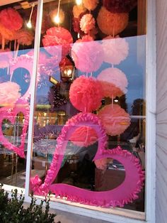 pink and white decorations in the window of a store