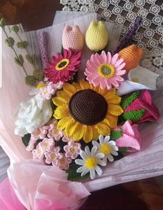 crocheted flowers in a bouquet on a lace doily with pink and yellow ribbons