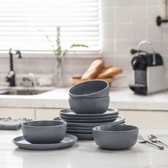 a stack of gray dishes sitting on top of a kitchen counter