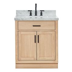 a bathroom vanity with marble top and wooden cabinetry on the bottom, along with two faucets