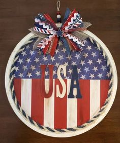 an american flag ornament hanging on a wall with the word usa written in red, white and blue