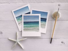 three pictures are placed next to a starfish on a white wooden surface with a brush