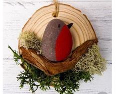 an ornament with a bird sitting on top of a piece of wood and moss