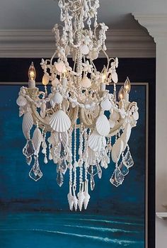 a chandelier hanging from the ceiling in a room with a painting on the wall