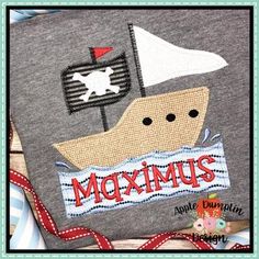 a close up of a piece of cloth with a boat on it and the words moximus