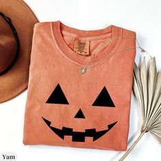 Pumpkin Face Comfort Colors® Shirt,Jack o Lantern Graphic Shirt,Spooky Season Shirt, Halloween Unique Shirt,Pumpkin Face Shirt,Pumpkin Face  ⭐ COMFORT COLORS 1717 UNISEX T-SHIRT 🌸 SIZE GUIDELINES 🌸 - This shirt fits true to size - If you want a comfortably fitted look, I recommend sticking with your regular t-shirt size - If you want a slightly oversized fit, I recommend sizing up one size - If you want a true oversized fit, I recommend sizing up two to three sizes 🌸 PRODUCT DETAILS 🌸 - 100% ring-spun cotton - Medium fabric (6.1 oz/yd² (206.8 g/m - Relaxed fit - Sewn-in twill label 🌸 CARE INSTRUCTIONS 🌸 - Machine wash: cold (max 30C or 90F) - Do not bleach - Tumble dry: low heat - Do not iron directly on design - Do not dryclean ⭐ You can contact me for more color, size and product o Pumpkin Pocket Shirt, Pumpkin Face Tshirt, Spooky Orange T-shirt For Fall, Orange Spooky T-shirt For Fall, Halloween Crew Neck Soft-washed T-shirt, Spooky Orange Fall T-shirt, Halloween Soft-washed Cotton T-shirt, Unique Shirt, Pumpkin Faces