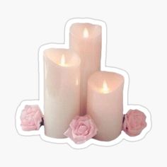 three white candles with pink roses on them