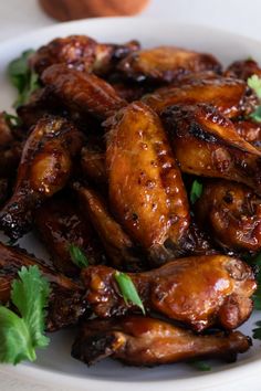 chicken wings with cilantro and parsley in a white bowl on a table