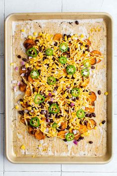 a tray filled with taco salad sitting on top of a counter next to a wooden spoon