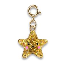 a gold glitter star charm with pink eyes and yellow sparkles on the inside of it