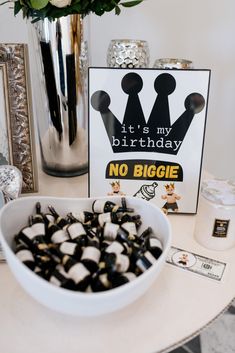 there is a bowl of black and white candies in front of a sign that says it's my birthday