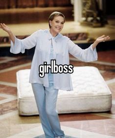 a woman standing on top of a bed with her arms spread out and the words girl boss