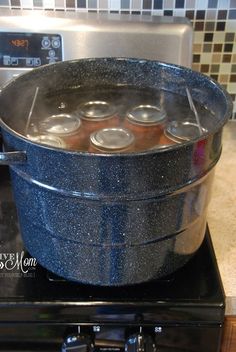 a large pot on top of a stove filled with water and cans of soda in it