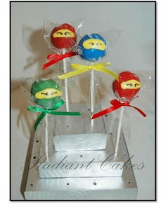 four lollipops in the shape of angry birds with bows on them are sitting in a clear box