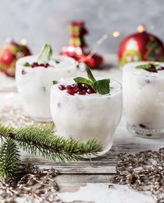 three glasses filled with ice and garnish on top of a table