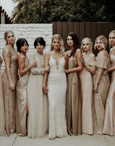 a group of women standing next to each other in long dresses and one is wearing a dress