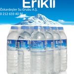 six bottled water bottles are stacked on top of each other in front of a mountain