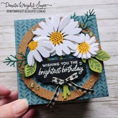 someone is holding up a card with daisies on it and the words, wishing you the brightest birthday