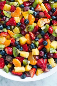 a white bowl filled with fruit salad on top of a table