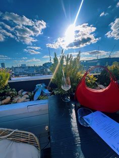 the sun shines brightly over an outdoor table with plants and wine glasses on it