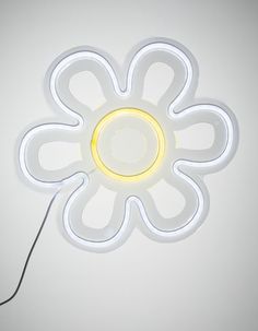 a white flower shaped light is on the wall