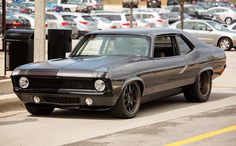 an old muscle car parked in a parking lot