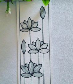 a black and white drawing of flowers on a paper with water lilies in the background