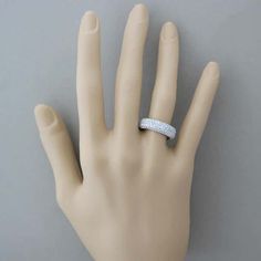 a person's hand with a wedding ring on top of their finger, against a gray background