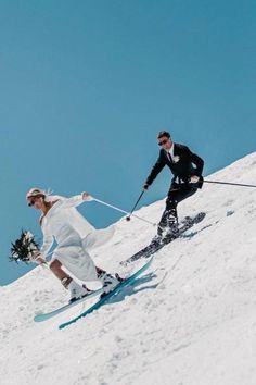 the bride and groom are skiing down the hill