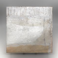 an abstract sculpture with white and brown paint on the top, in front of a gray background