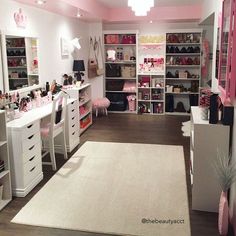 a room filled with lots of white furniture and pink accents on the walls, along with shelves full of personal items