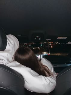 a woman sitting in the back seat of a car with her head resting on someone's arm