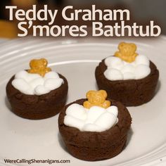 three cookies with marshmallows and teddy bears in them on a white plate