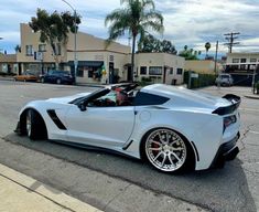 a white sports car parked in front of a building