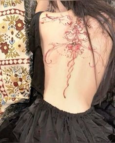 the back of a woman's body with tattoos on it