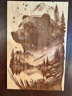 a wood carving of a bear with mountains and trees in the background, is shown