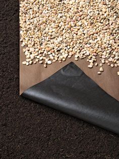 a pile of gravel sitting on top of a wooden floor next to a black piece of cloth