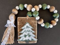 a wooden beaded bracelet with a christmas tree on it and a tassel hanging from the clasp