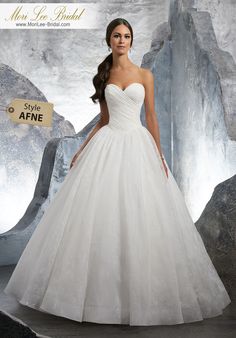 a woman in a white wedding dress standing next to rocks