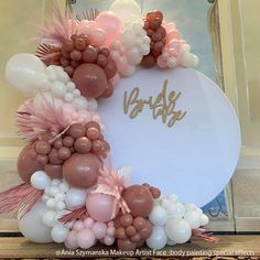 a wreath made out of balloons with the word baby written on it in gold and pink