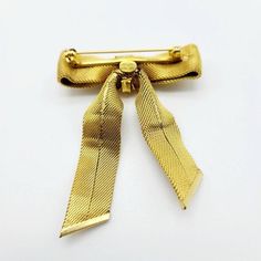 Very nice vintage Christian Dior bow brooch in very good condition with signs of wear Elegant Yellow Gold Brooches For Party, Elegant Yellow Gold Party Brooches, Elegant Brooch Pins For Vintage Events, Elegant Vintage Brooch Pins, Vintage Bow Tie Brooch As Gift, Vintage Gold-tone Brooches For Formal Occasions, Classic Gold Brooches For Vintage Events, Classic Wedding Brooch With Bow, Elegant Gold Brooches With Ribbon