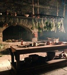 a table with pots and pans on it in front of a brick oven at night