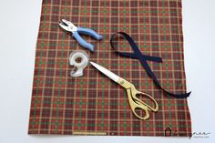 some scissors are laying on a plaid cloth