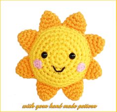 a crocheted yellow star with black eyes and pink cheeks is shown in front of a white background