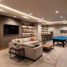 a living room filled with furniture and a pool table in front of a flat screen tv