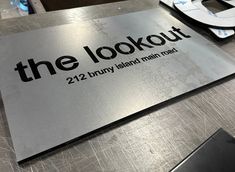 the lookout sign is on top of a metal table with scissors and other items