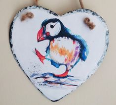 a heart shaped hanging decoration with a bird painted on it