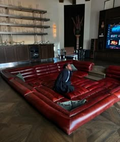 a man sitting on top of a red leather couch